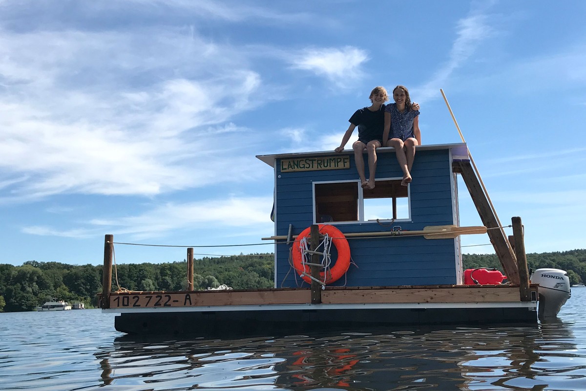 Janne Siemer (links) und Charlotte Hornemann sitzen auf dem Dach ihres selbstgebauten Hausboots 