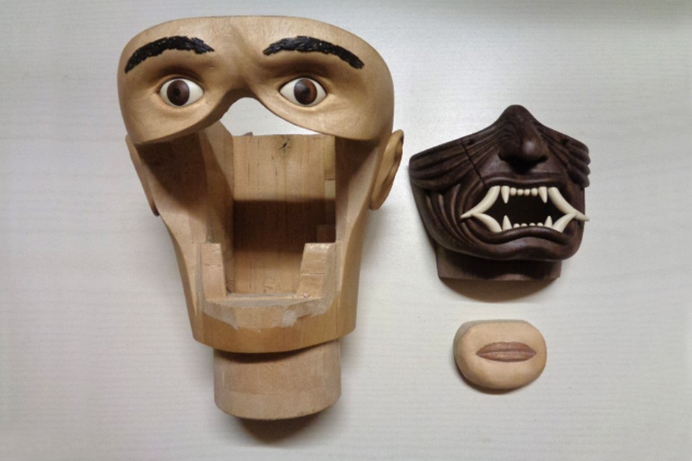 
				Zähne und Nasenpartie sind Teil der Maske. Sie werden ins Gesicht eingesetzt.

			