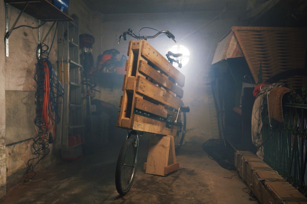 
				In der Werkstatt steht ein Fahrrad aus einer Holzpalette.

			