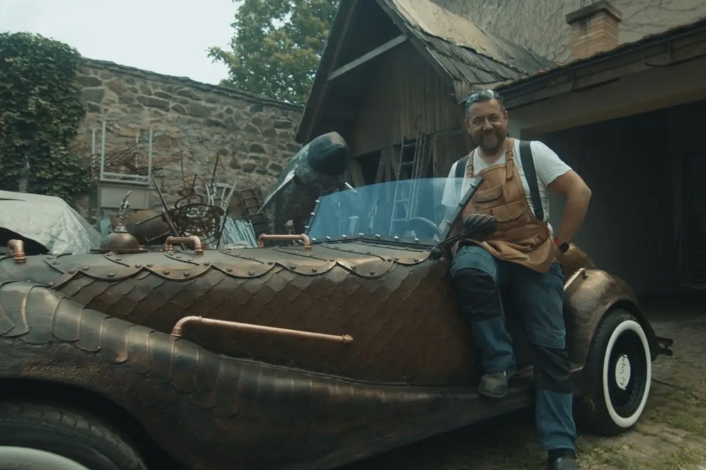 
				Vepi sitzt auf seinem Drachenwagen.

			